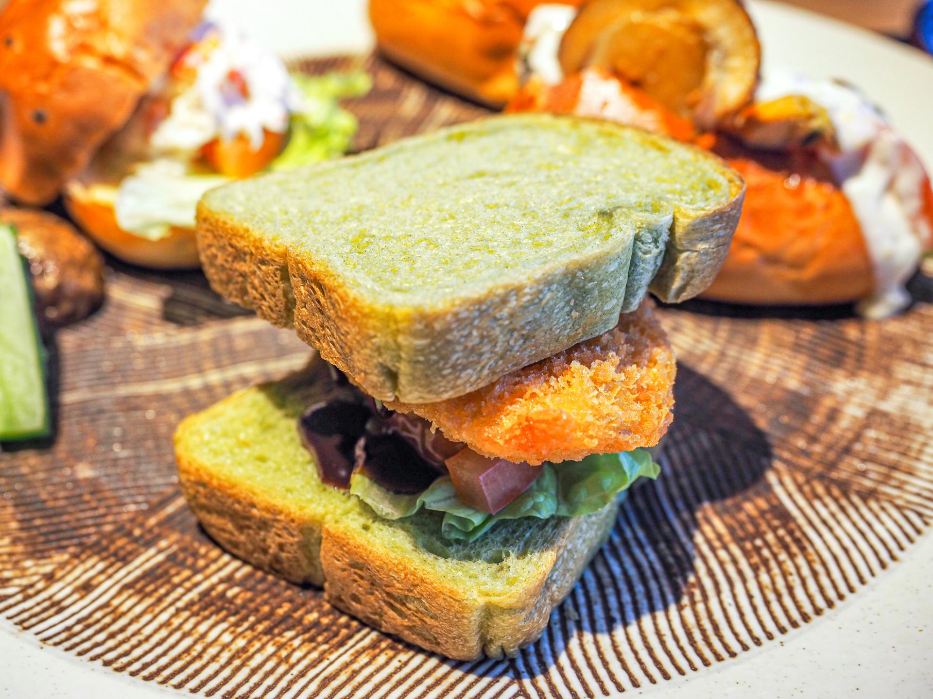 Deep-fried salmon and vegetables with sweet miso paste and mayonnaise sauce on spinach bread