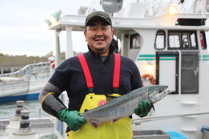 秋鮭を持つ（有）マルヤ海産　坂本悠さん