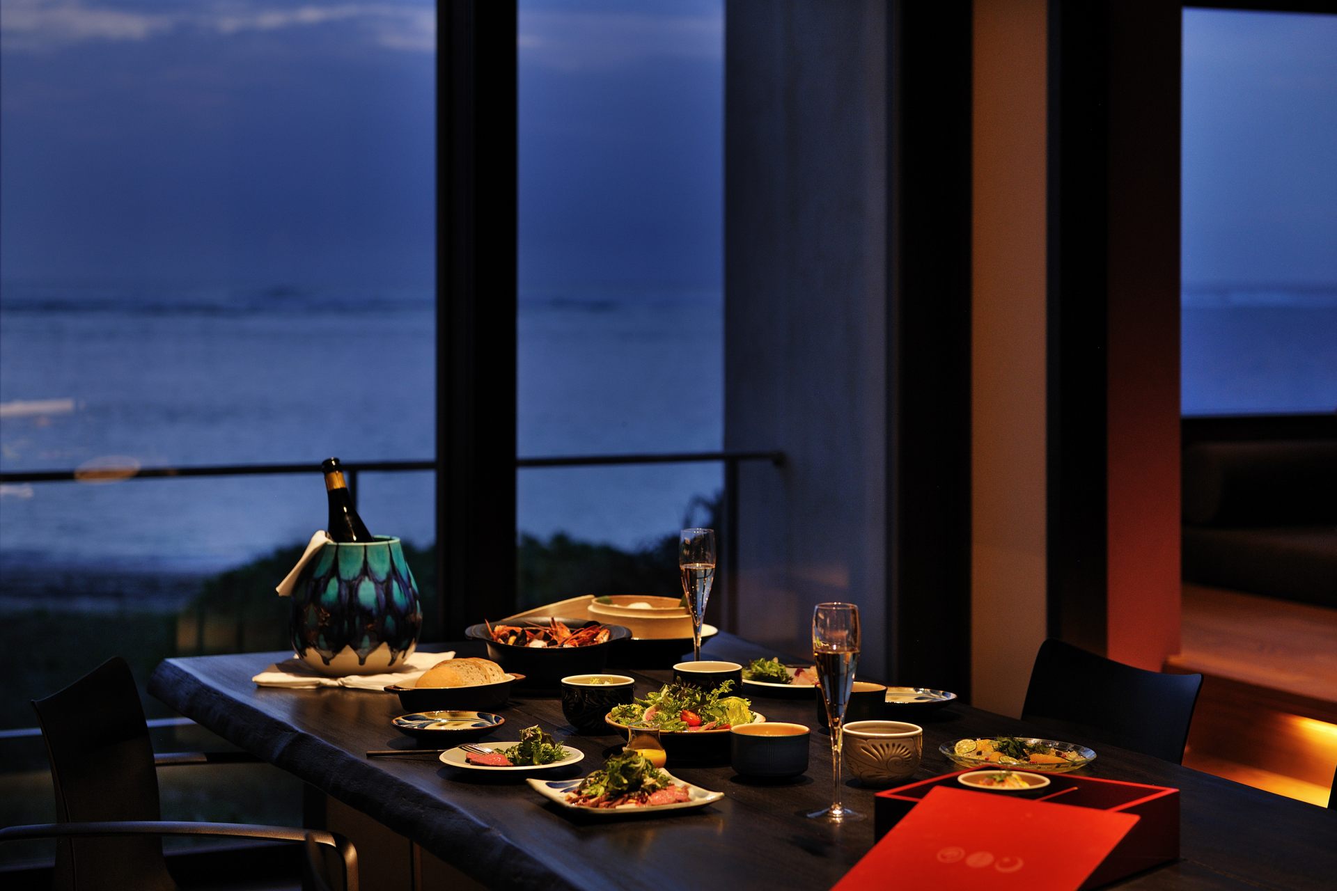 星のや沖縄の客室では「土間ダイニング」と呼ばれるスペースに大きなダイニングテーブルが置かれ、インルームでの朝食や夕食を快適に楽しめる。遠浅の海岸線の眺めは素晴らしく、特に目の前に沈んでいくサンセットは絶景だ。
