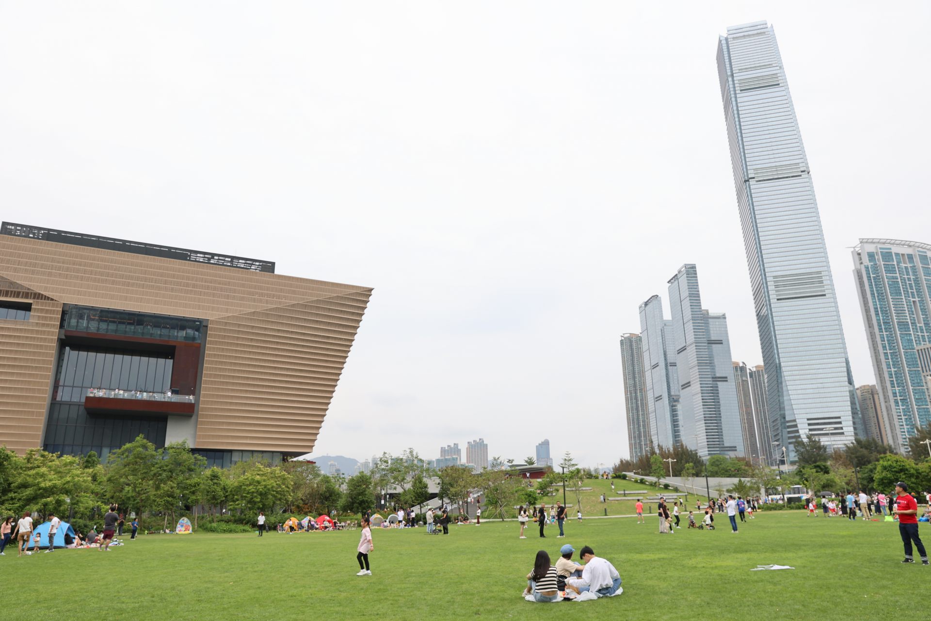 芝生越しに眺める「香港故宮文化博物館」（左）と香港一高い「ICC（環境貿易廣場）」（右）