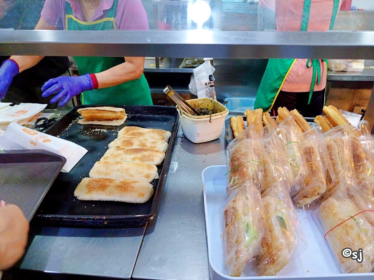 焼きたての焼餅に油條を挟んでいるところ