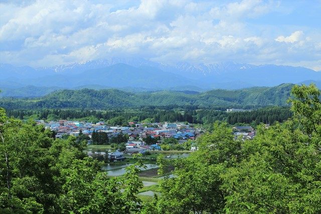 東屋脇より望む飯豊連峰の様子です。
飯豊連峰をバックに西会津町野沢地区の集落と水田を望むことができます。