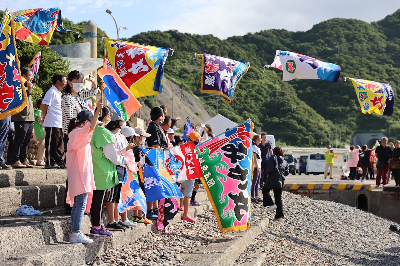 下甑島では早朝の到着にもかかわらず、島民の方々が大漁旗を手に盛大に歓迎してくれた