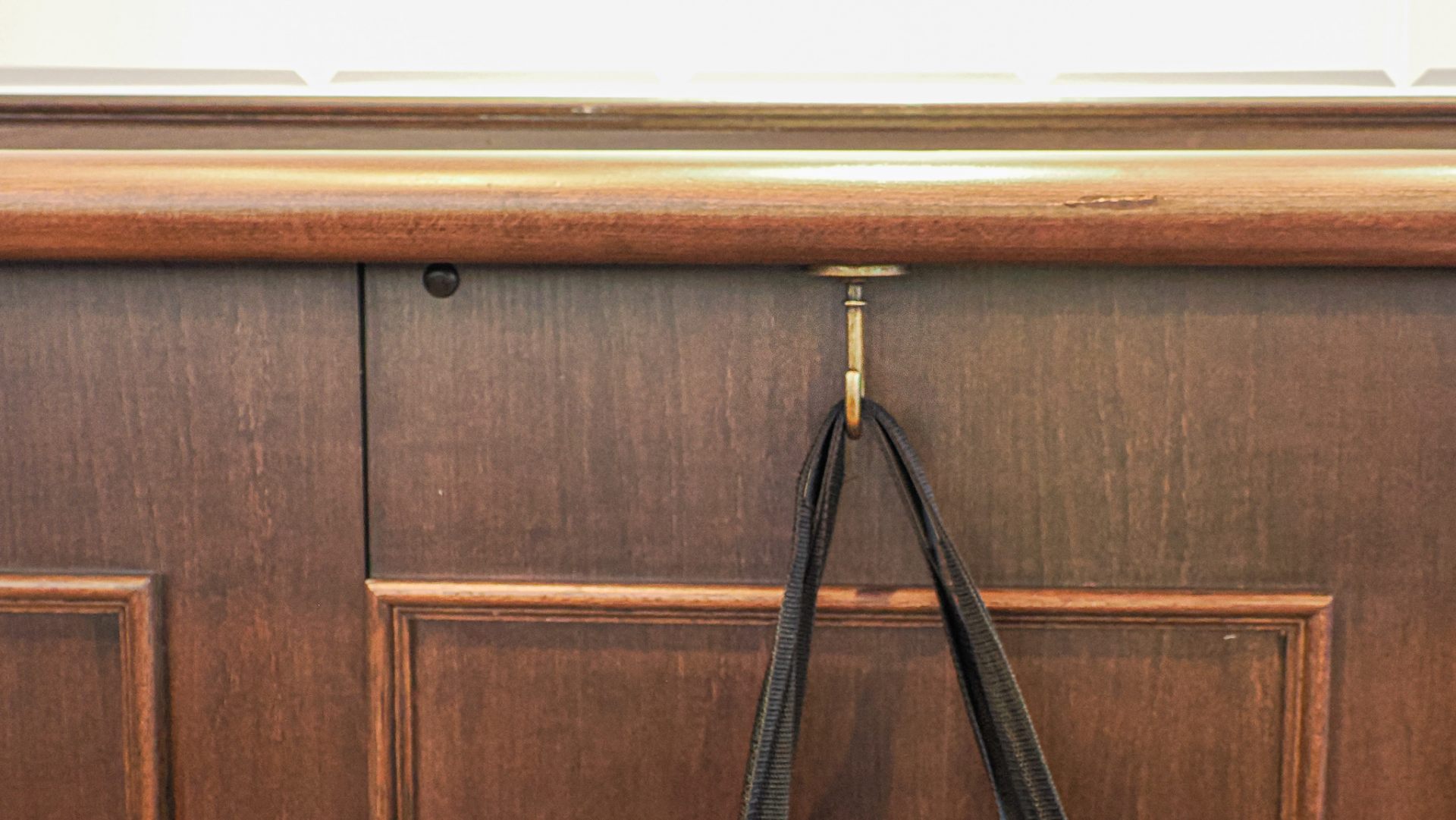 A bag hanger under the counter tables along the walls