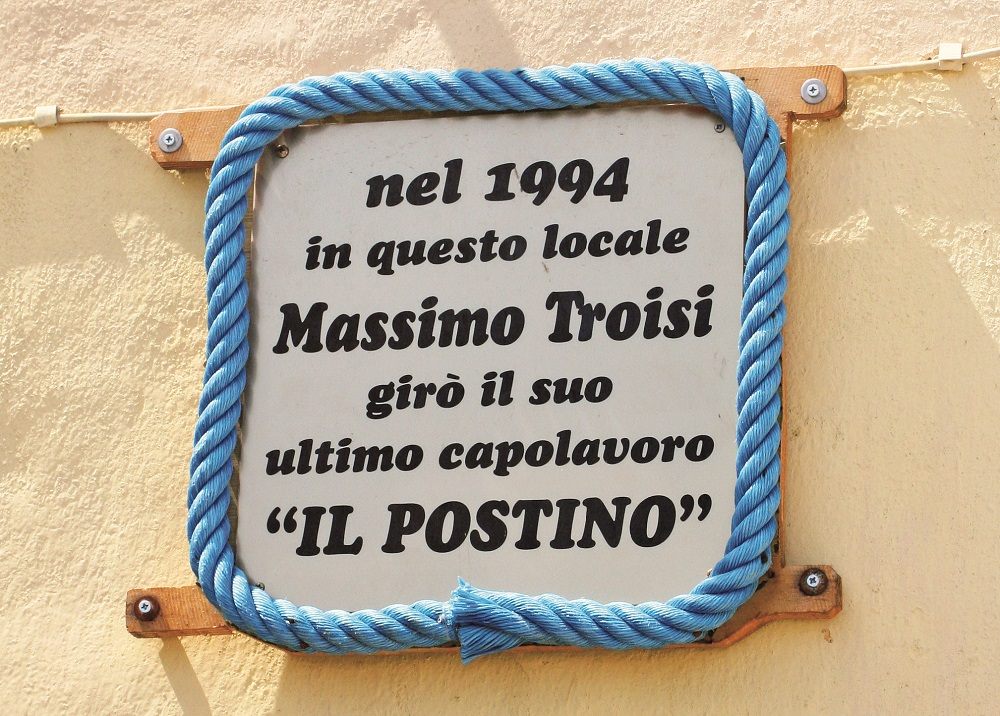 コッリチェッロの浜の一角にある、撮影地を示す看板。「M.トロイージの遺作」とある