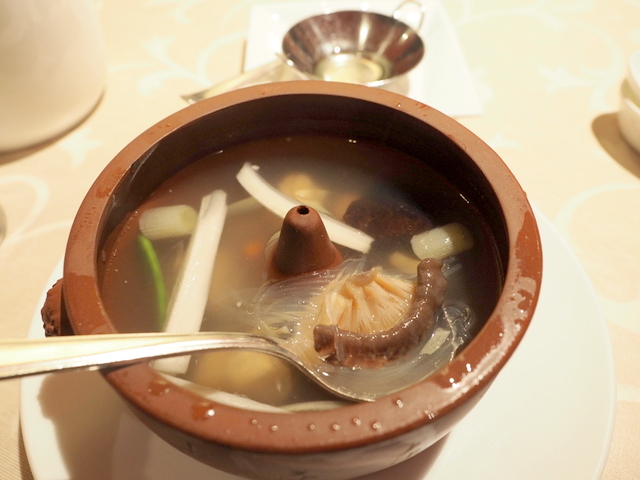 Chicken soup steamed in a crock with ginger oil